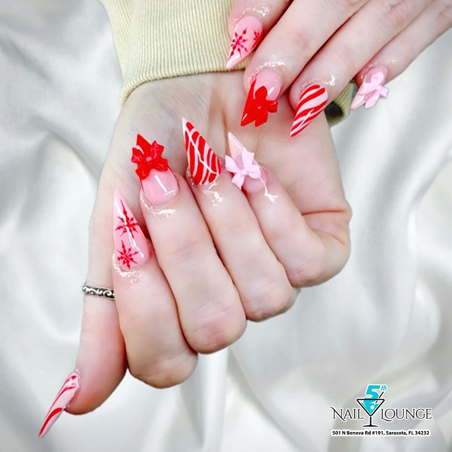 Pink and red holiday nail art with hand-painted candy canes, bows and snowflakes