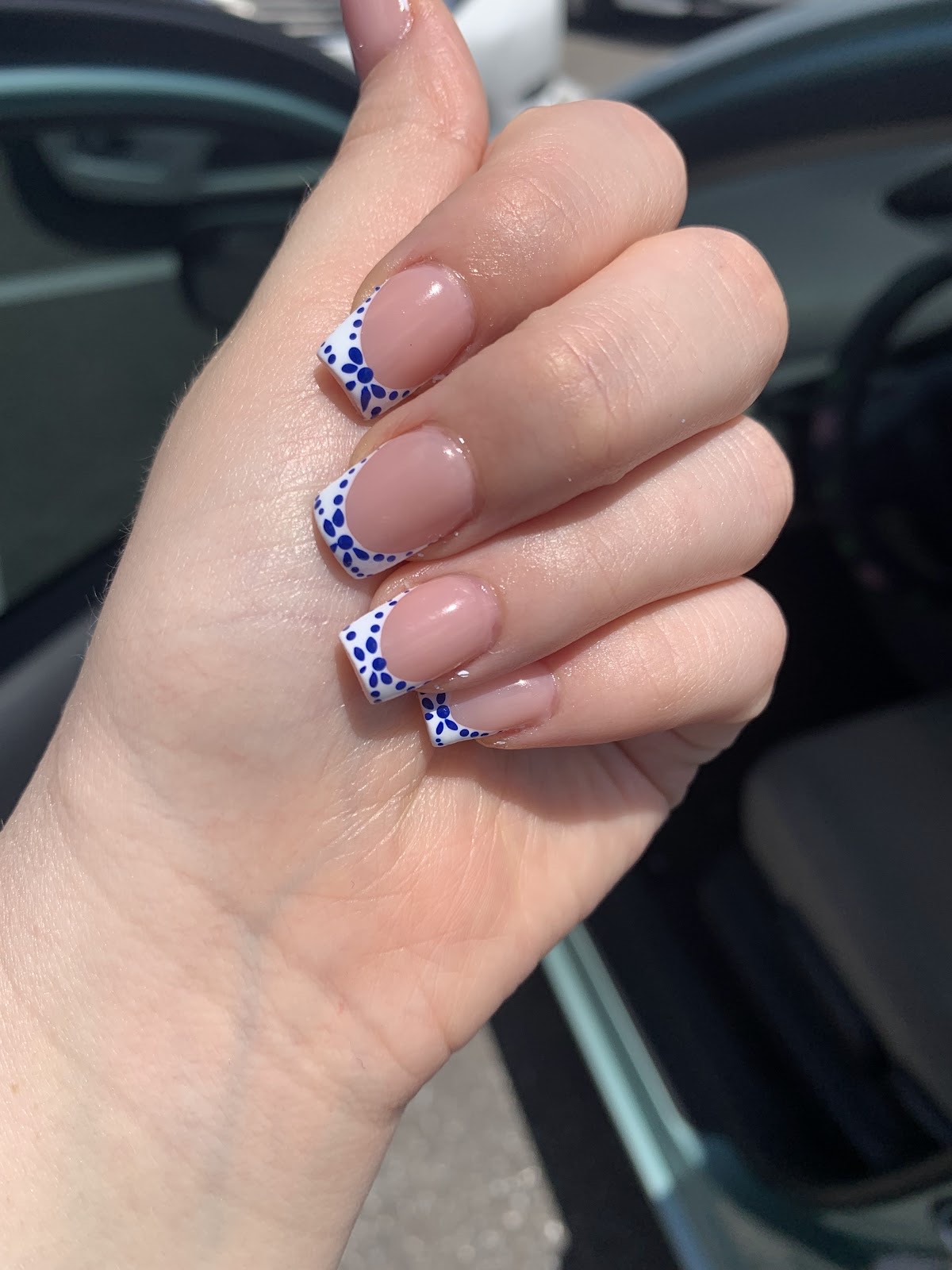 Nude French manicure with blue and white floral tip detailing