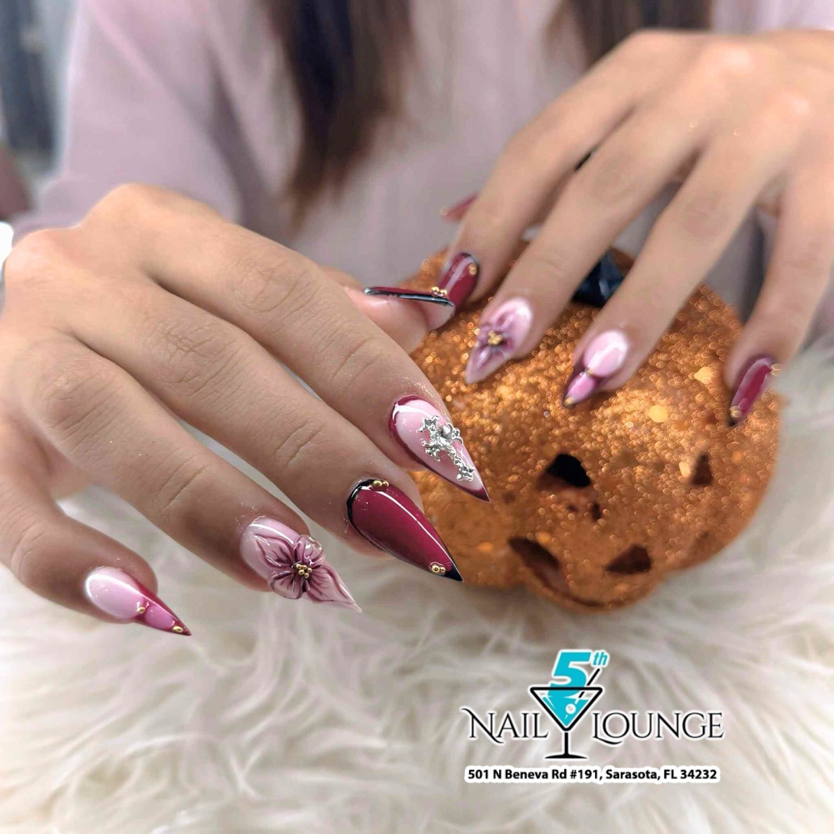 Custom hand-painted stiletto nails in wine red and blush pink with rhinestone accents at 5th Nail Lounge Sarasota